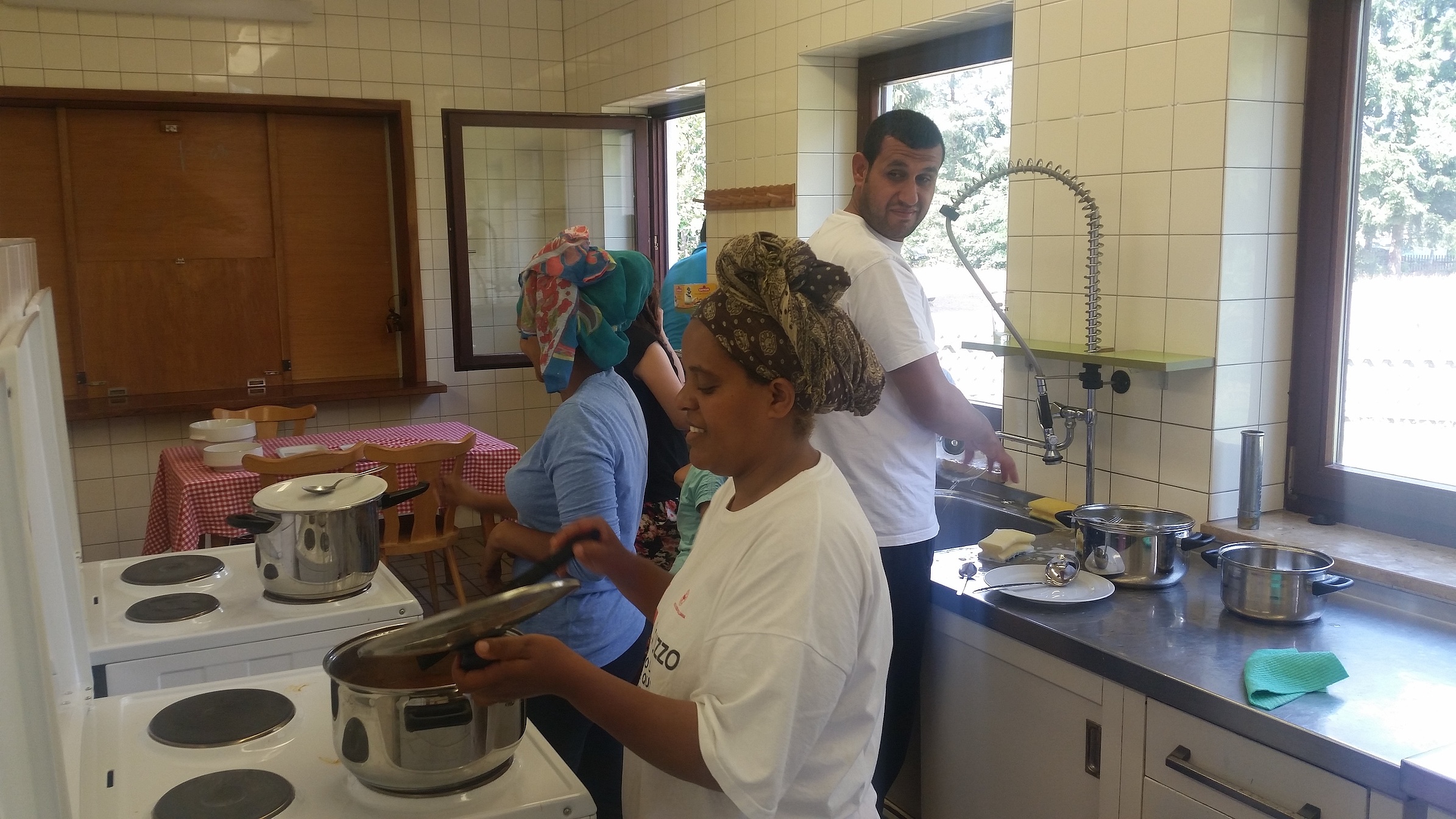 Besucherinnen und Besucher des MGH beim gemeinsamen Kochen.