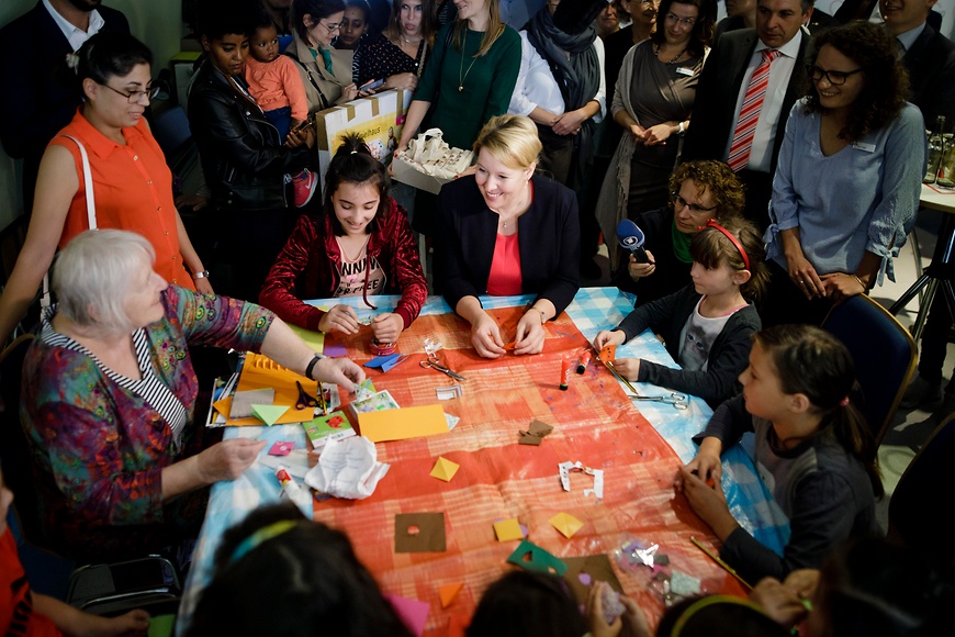 Bundesfamilienministerin Dr. Franziska Giffey spricht mit Kindern und einer Seniorin an einem Tisch im Mehrgenerationenhaus Bad Rodach. 
